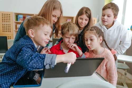 Schulkinder arbeiten gemeinsam am Laptop