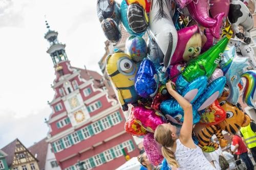 vor dem Alten Rathaus in Esslingen betrachtet eine Frau ein großes Bündel Luftballons