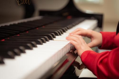 Kinderhände an einer Klaviertastatur