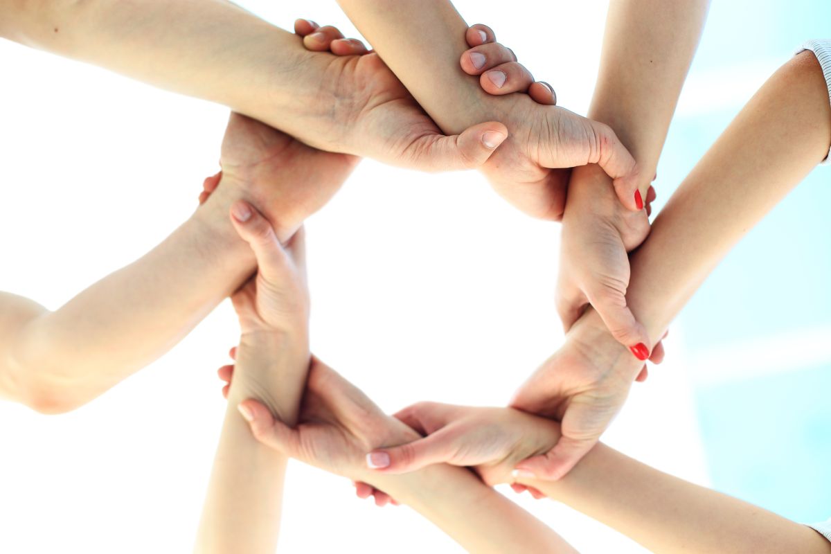Viele Hände bilden gemeinsam einen Kreis.