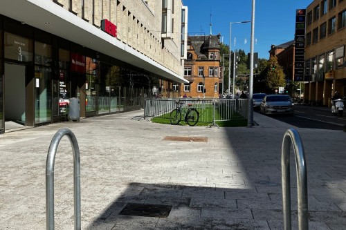 Neu gestaltete Fläche vor dem QBUS mit Fahrradständern und Grünflächen
