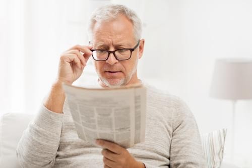Mann mit Brille liest Zeitung
