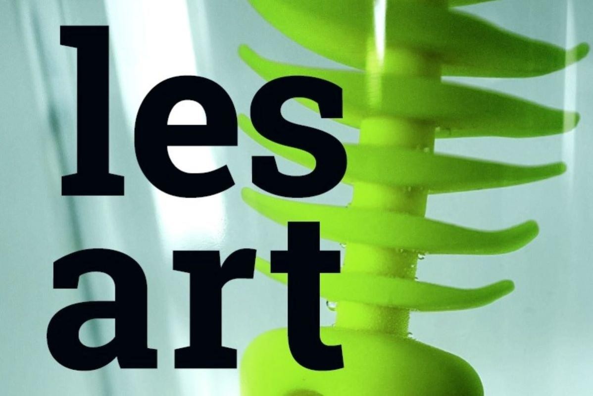 schwarzer Schriftzug lesart, im Hintergrund ist ein grünes Plastikobjekt zu sehen, das an Fischgräten erinnert