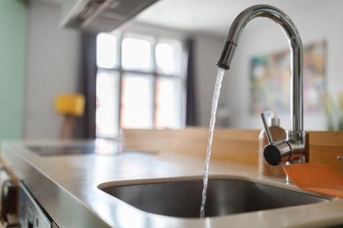Wasser fließt aus einem Hahn in der Küche