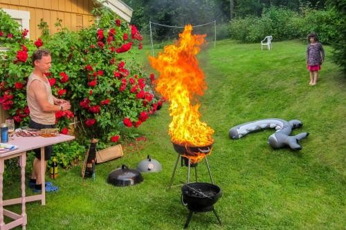 Ein Mann und ein Kind neben einem in Brand geratenen Grill.