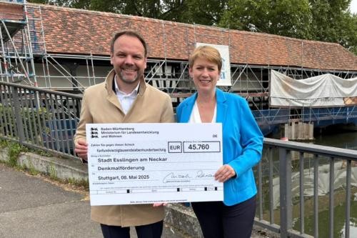 Staatssekretärin Andrea Lindlohr überreicht Erstem Bürgermeister Ingo Rust vor dem Wasserhaus einen Spendenscheck.