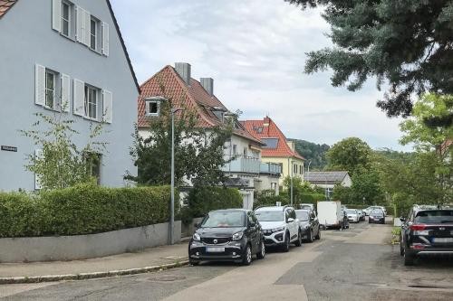 Straßenbeleuchtung in Hohenkreuz aus Sicht der Straße, am linken Rand parken Autos, daneben stehen Einfamilienhäuser