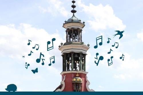 Glockenturm des Alten Rathauses in Esslingen mit gezeichneten Noten und Silhouetten von Schwalbe, Igel, Mücke und Schmetterling