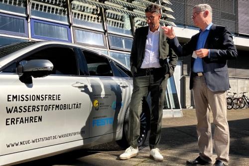 OB Matthias Klopfer und Prof. Dr.-ing. Walter Czarnetzki von der Hochschule Esslingen stehen vor dem Wasserstoff-Auto