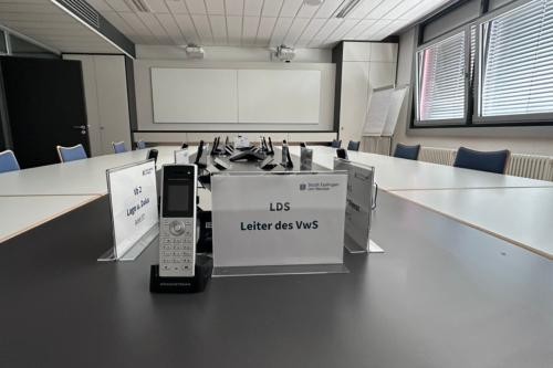 Die Ruhe vor dem Sturm im Verwaltungsstaab, leere Stühle, Schilder und Telefone.