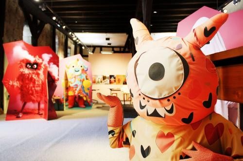 Große, bunte, nette Monster aus Stoff stehen in einem Ausstellungsraum