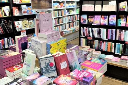 Bücherstapel und Bücherregale in der Romance-Abteilung im Buchladen