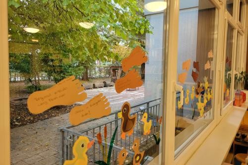Gestaltete Fußabdrücke an Kita-Fensterscheibe