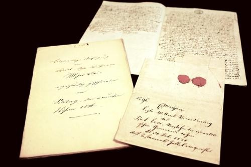 drei historische, handschriftliche Dokumente, eines davon mit zwei roten Siegeln