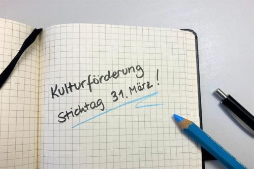 kariertes Notizbuch mit Notiz Kulturförderung Stichtag 31. März!