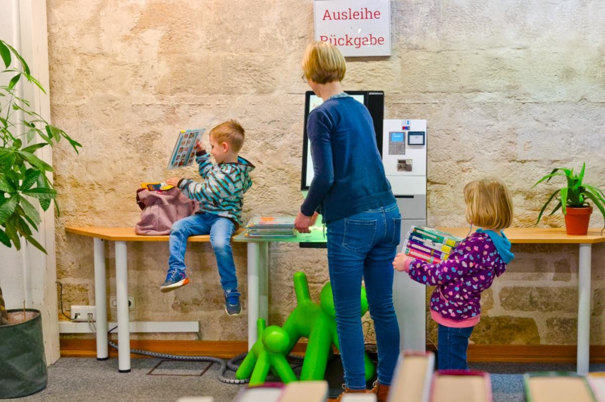 Anmeldung und Ausleihe Familie leiht am Selbstverbuchungsgerät Medien aus