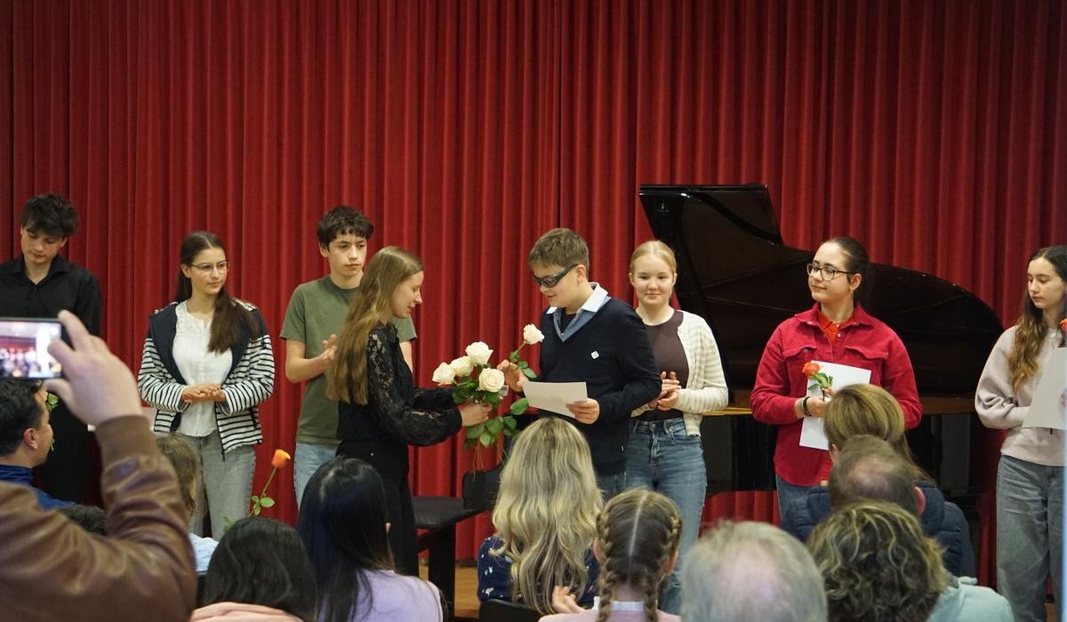 Preisträger:innen bekommen Rosen überreicht