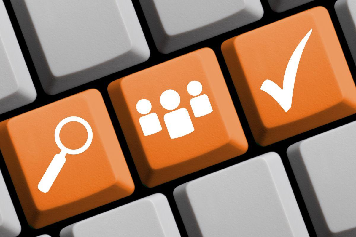 Drei orangefarbene Tasten Computertastatur mit Symbolen: Lupe, stilisierte Personen, Haken