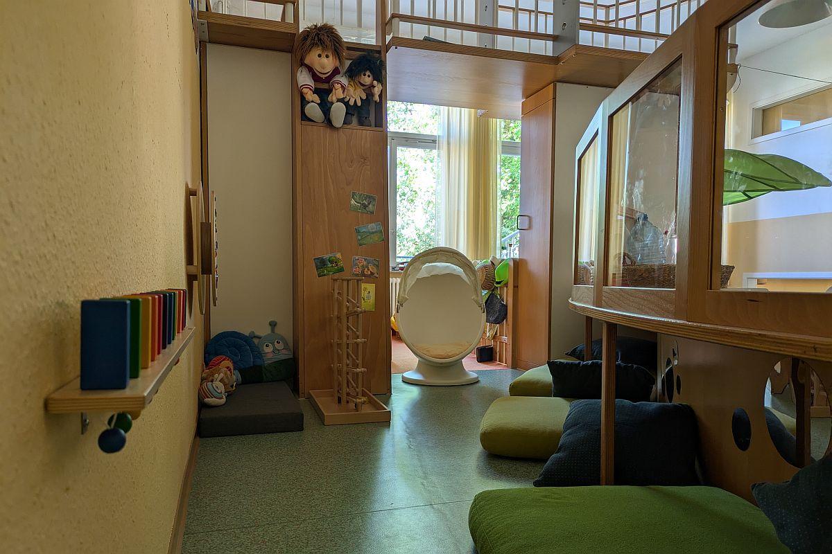 Die Sinnesecke mit Spielmaterialien an Wand und Fußboden sowie Sitzkissen in der städtischen Kita Konsumstraße