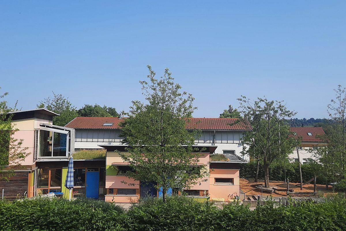 Die Gebäuderückseite der städtischen Kita Michael-Stifel-Platz mit Hecken und Bäumen