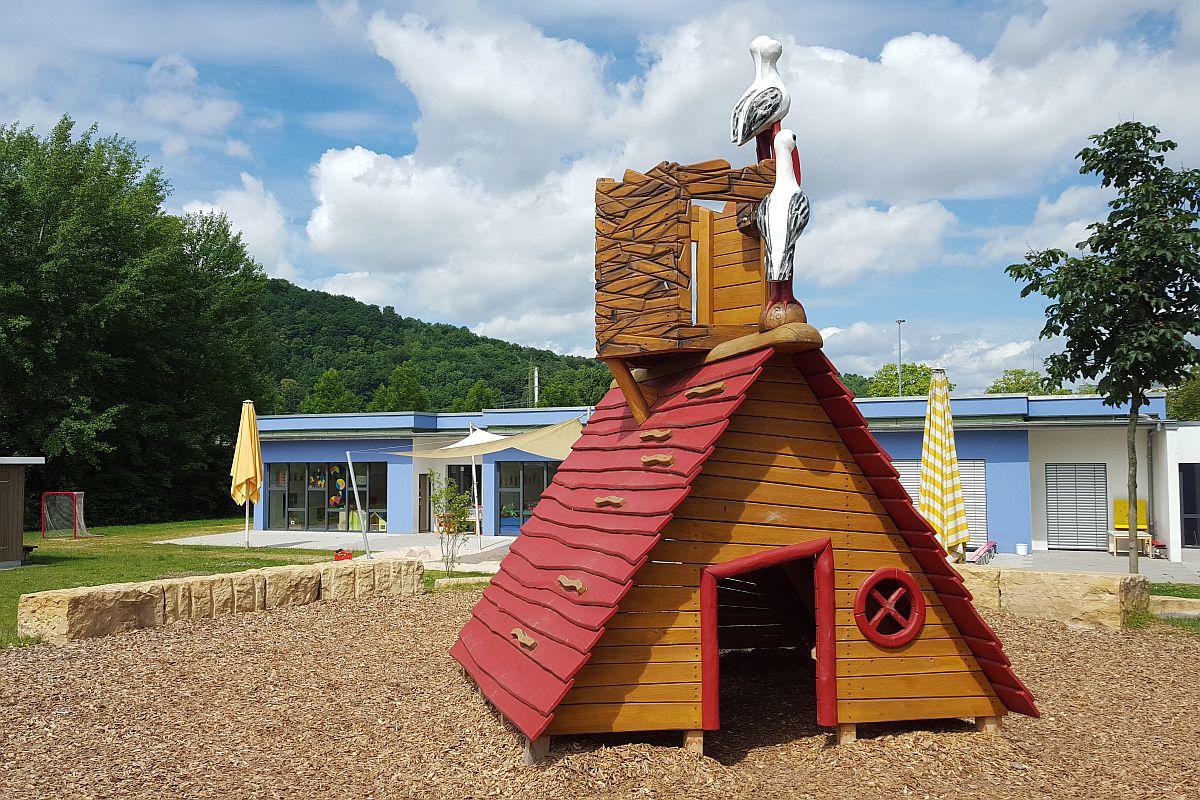 Der Garten mit Spielhaus und Gebäude der städtischen Kita Auenweg