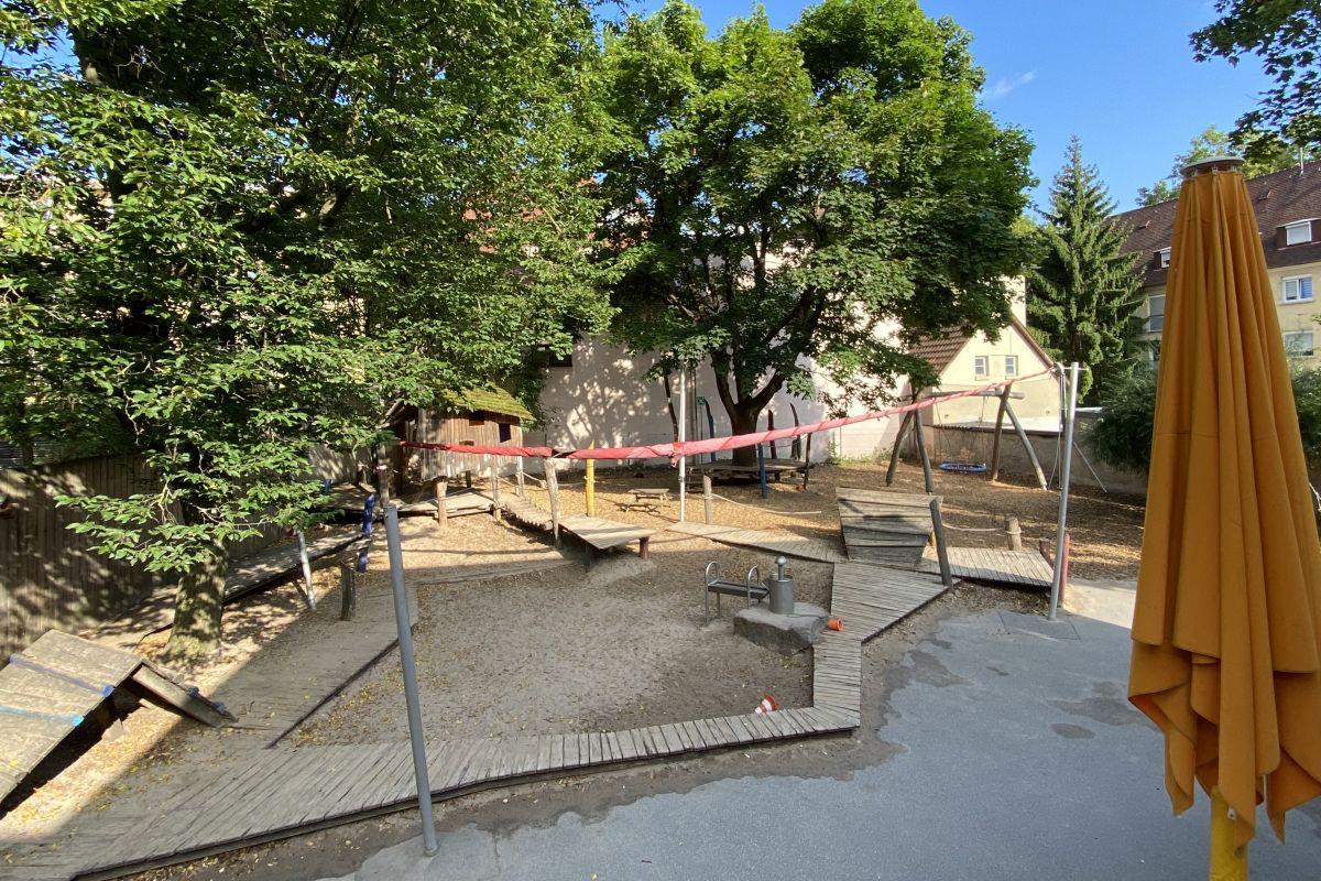 Der Sandkasten, der Spielturm und die Nestschaukel im Garten der städtischen Kita Uhlandstraße