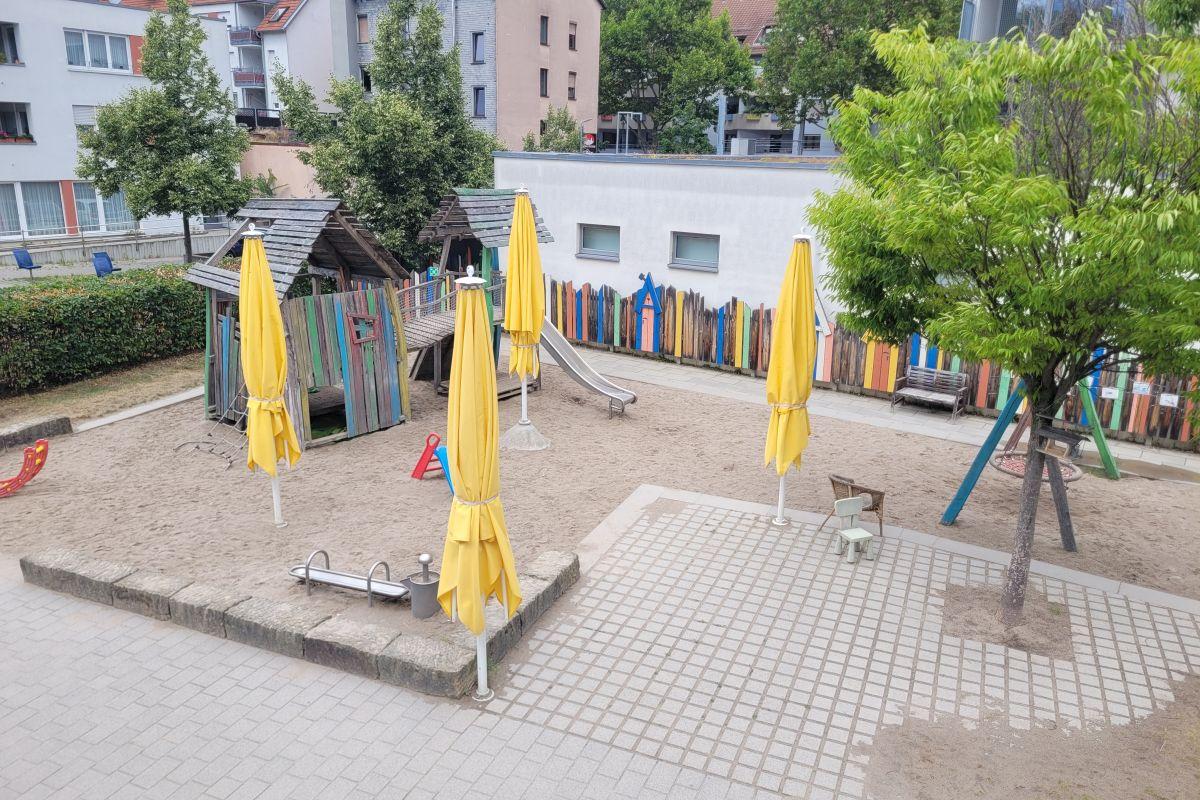 Der Sandkasten und das Spielhaus im Garten der städtischen Kita Weilstraße 