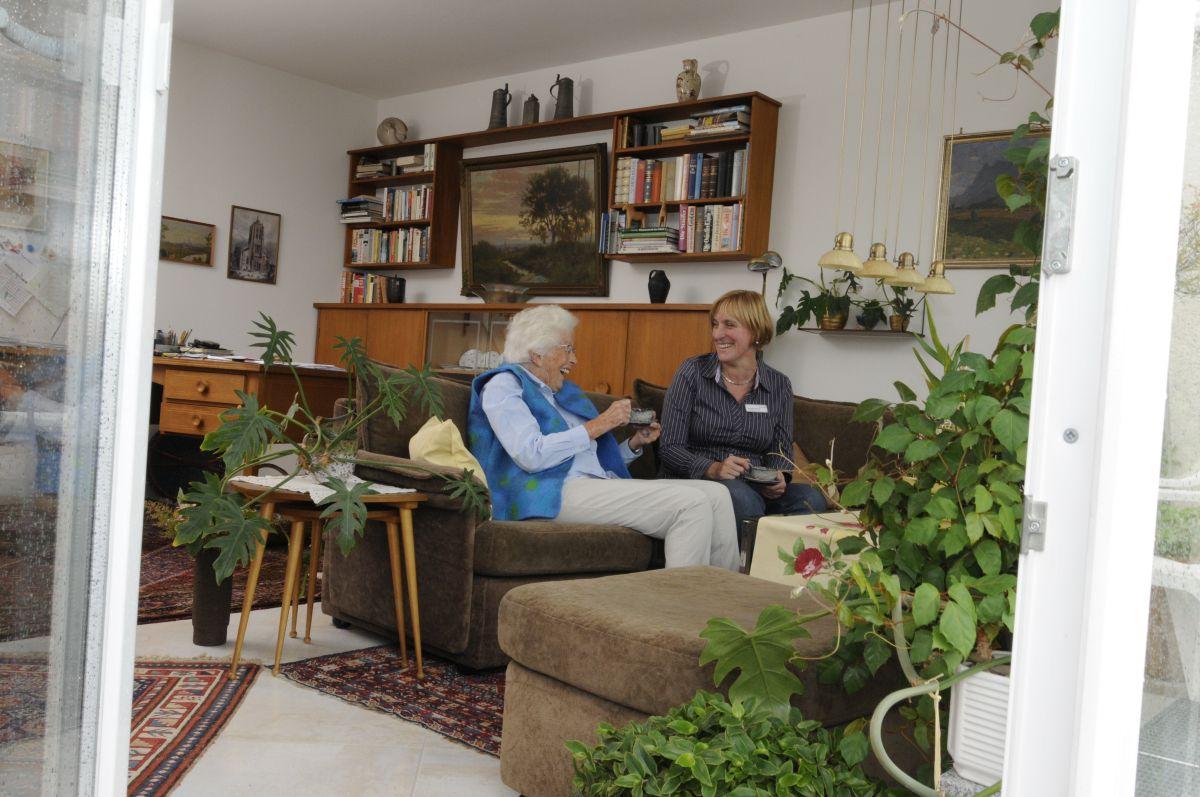 Foto Wohnstift Radäcker - Seniorin und Frau mittleren Alters die sich in Wohnzimmer unterhalten