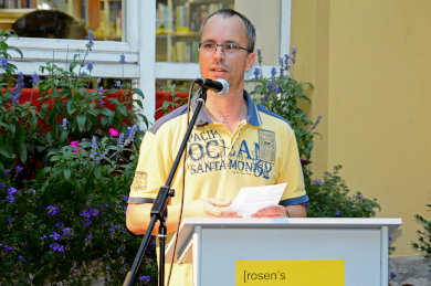 Zu sehen ist Andreas Roos am Stehpult