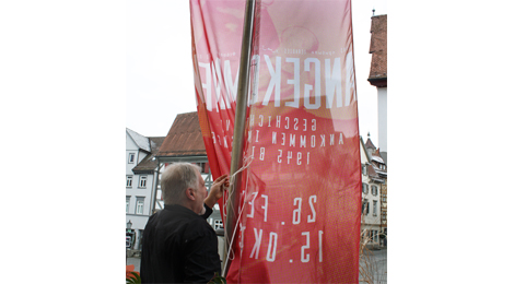 Die Fahne zur Ausstellung wird gehisst.