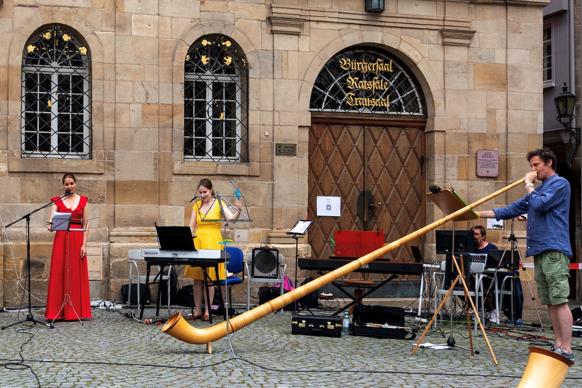 Alphorn, Sopran und Glockenspielerin am Keyboard vor dem Alten Rathaus