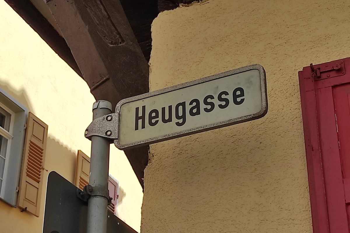 Straßenschild der Heugasse in der Esslinger Altstadt, im Hintergrund Fachwerkhäuser