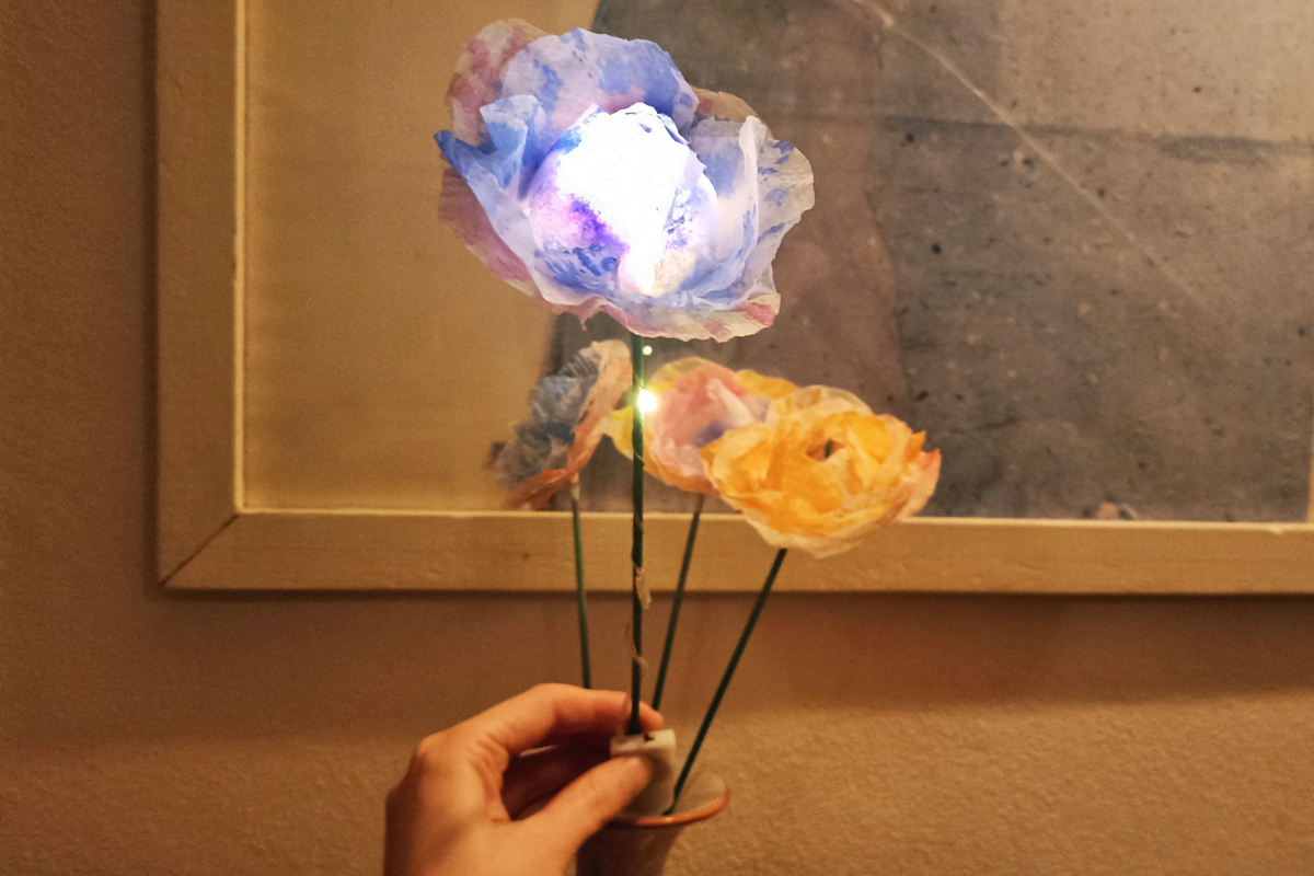 Kunstblume mit einer leuchtenden Blüte. Kunstblume mit einer leuchtenden Blüte.