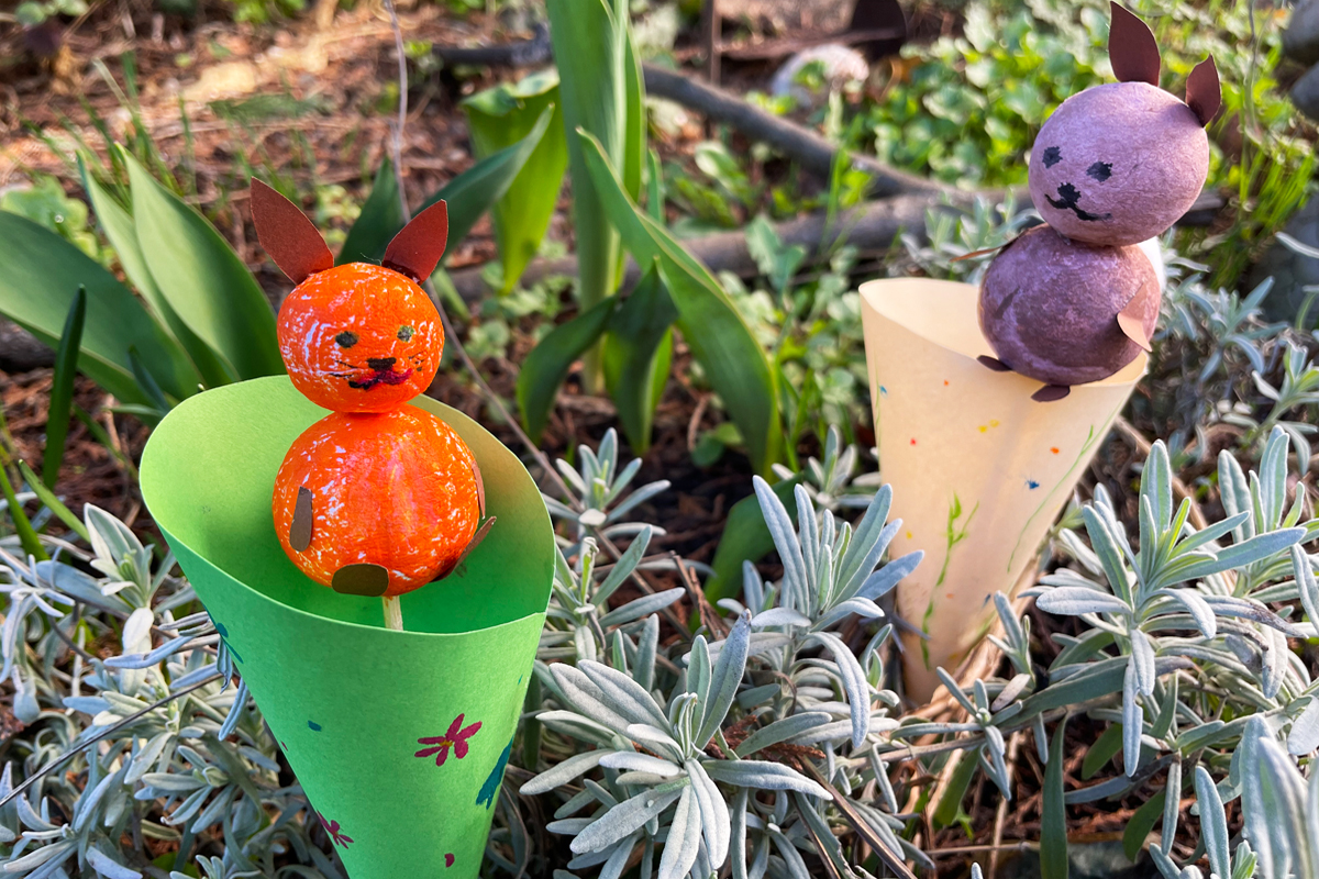 Pompon-Hasen hassen, die aus bunten Wollkugeln gebastelt sind.