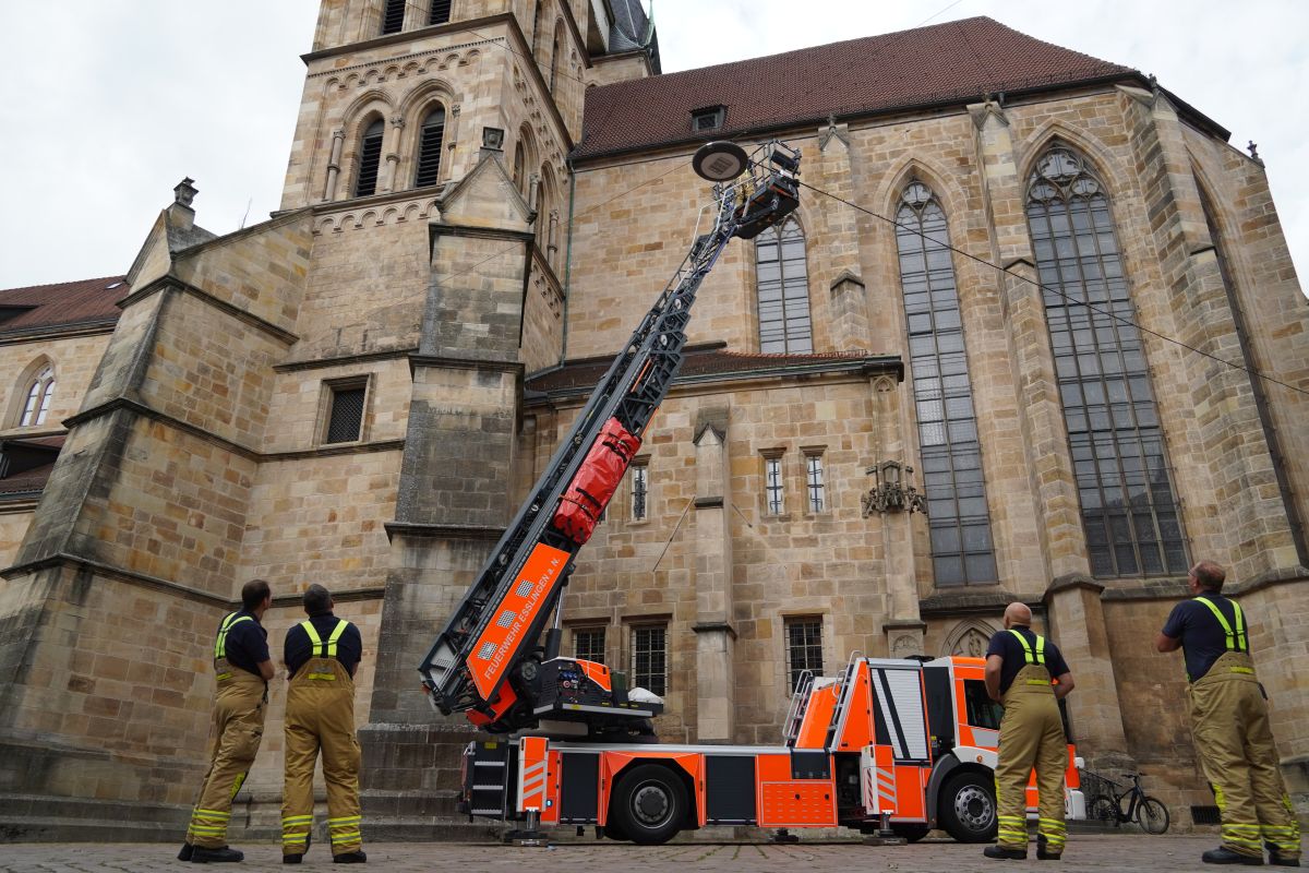 Drehleiter vor Kirche mit Feuerwehrangehörigen