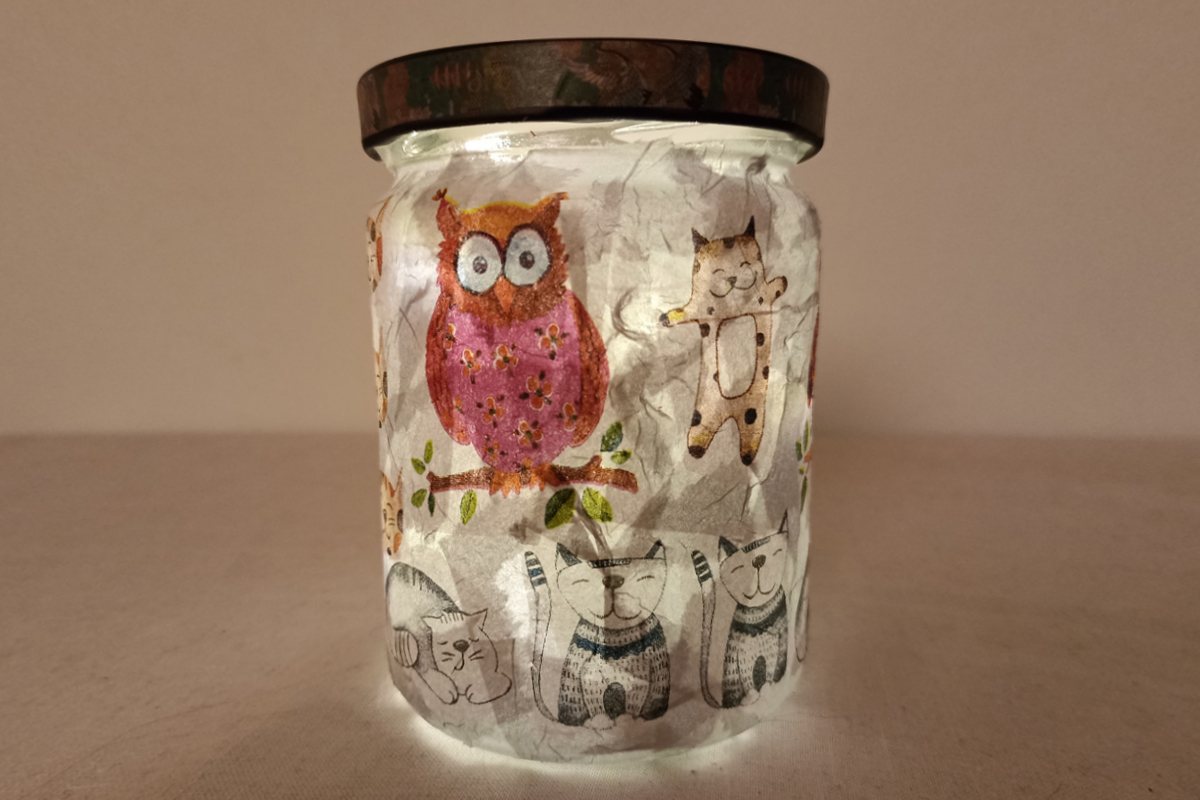 Beleuchtetes Glasgefäß, das mit selbst verziertem Papier ausgekleidet ist.