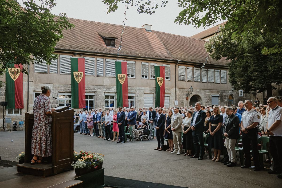 Die Mitglieder des Gemeinderats und die Bürgerstaft stehen während der Verpflichtung auf