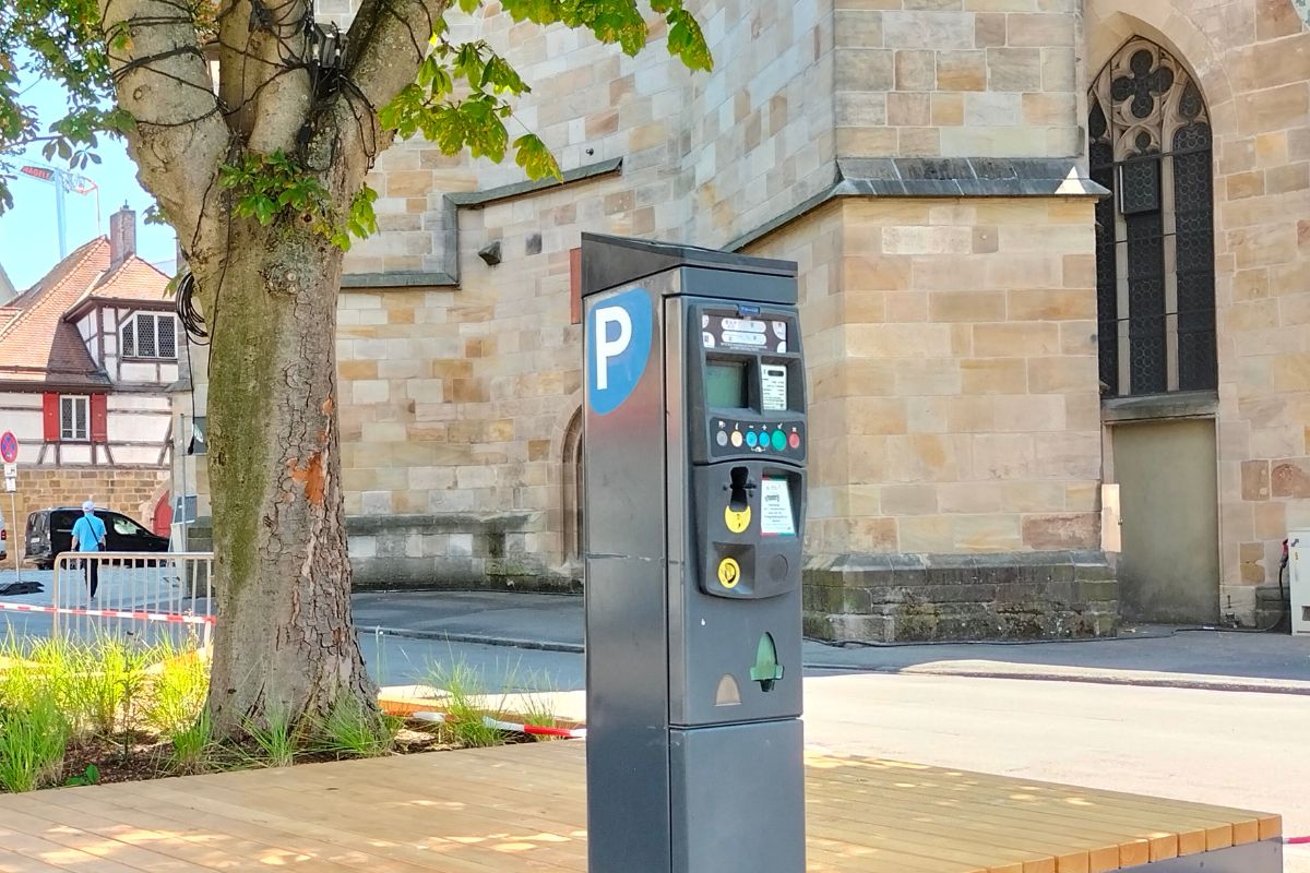 Parkschein-Automat am Esslinger Marktplatz, im Hintergrund ein Baumbeet und die Stadtkirche St. Dionys