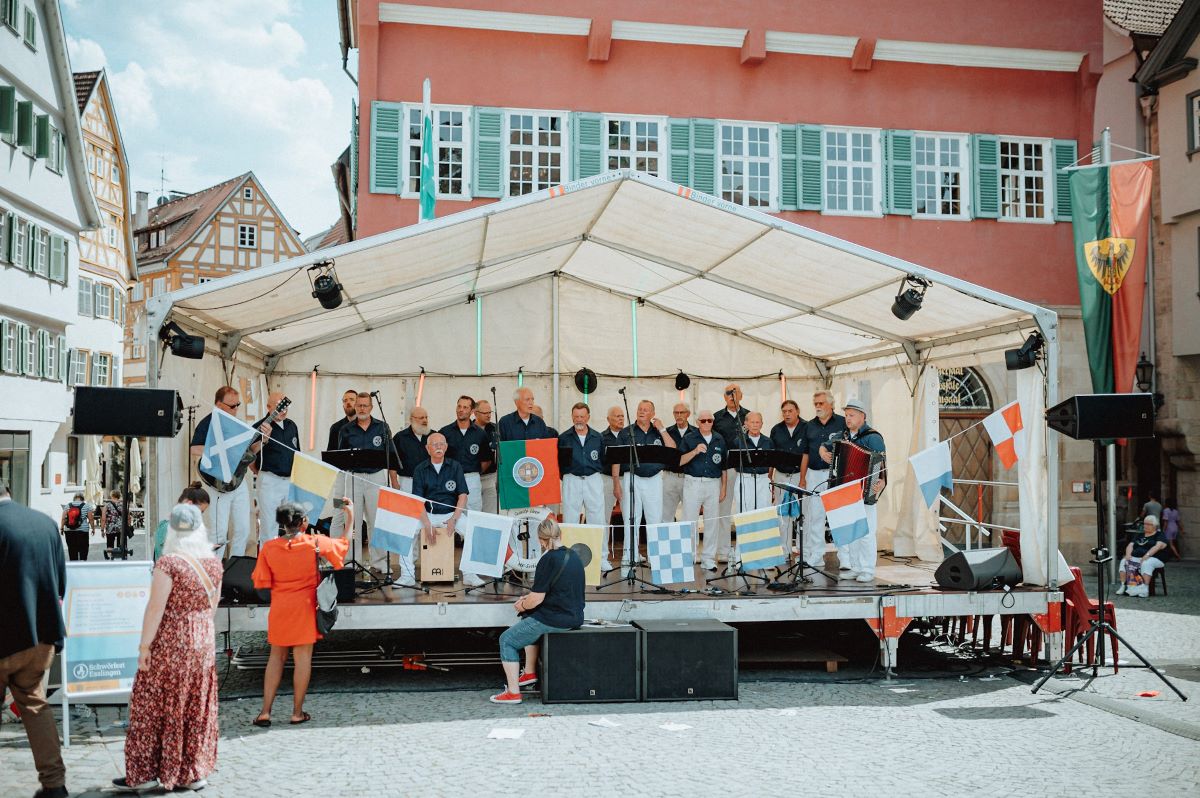 Marinechor auf einer weiß überdachten Bühne auf einem Platz