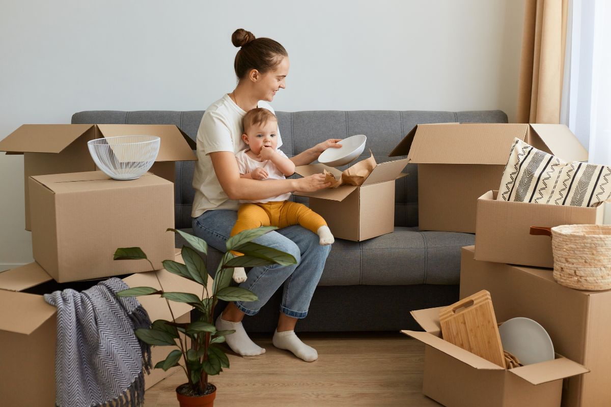 Junge Mutter mit Kind zieht in eine neue Wohnung ein