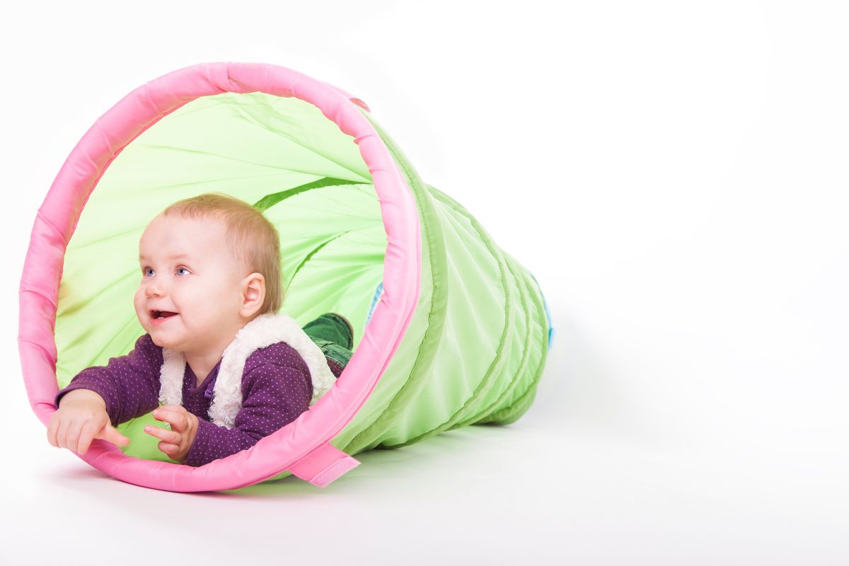 Tunnel Baby krabbelt durch einen grünen Tunnel