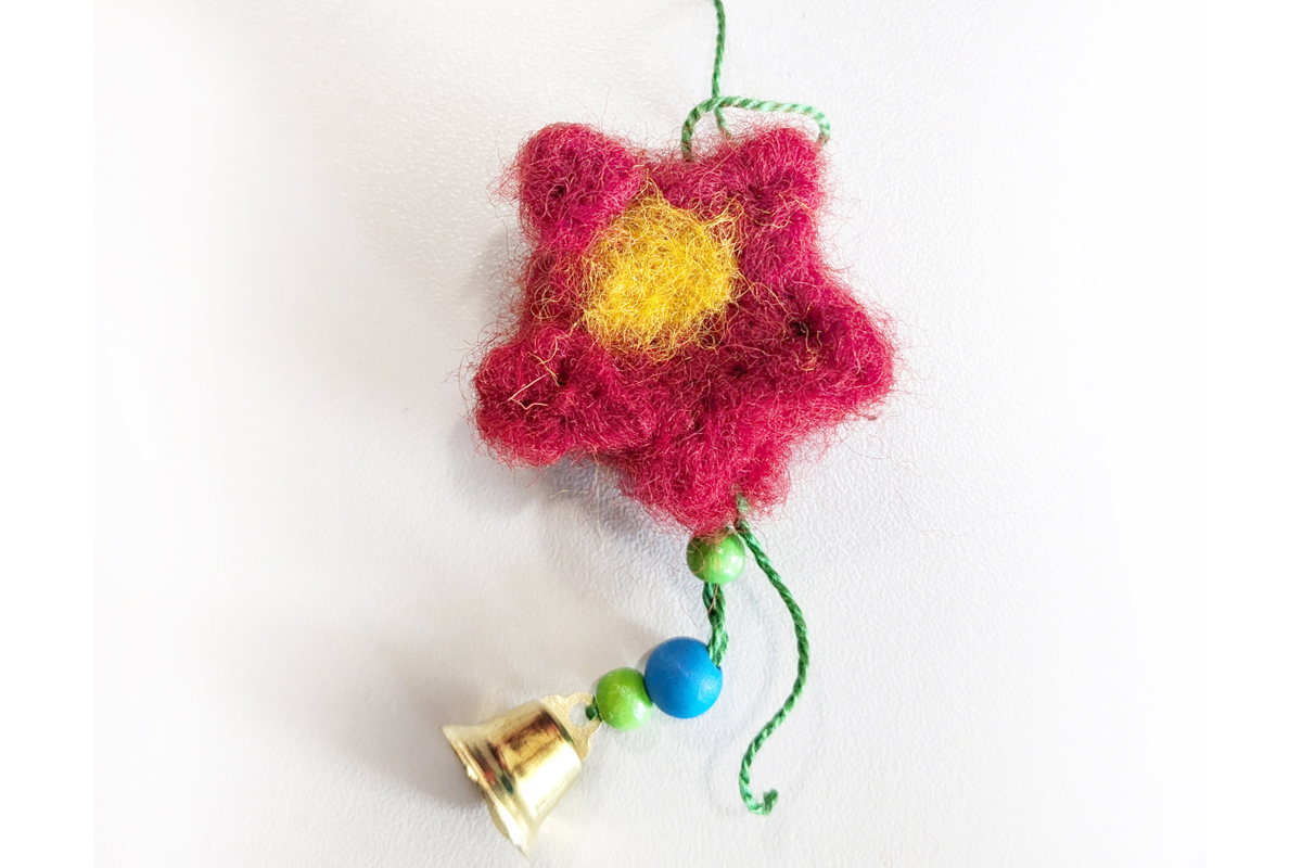 Mobile mit Filzmotiv Schmuck-Schnur mit einer gefilzten Blume, Holzperlen und einem Glöckchen.