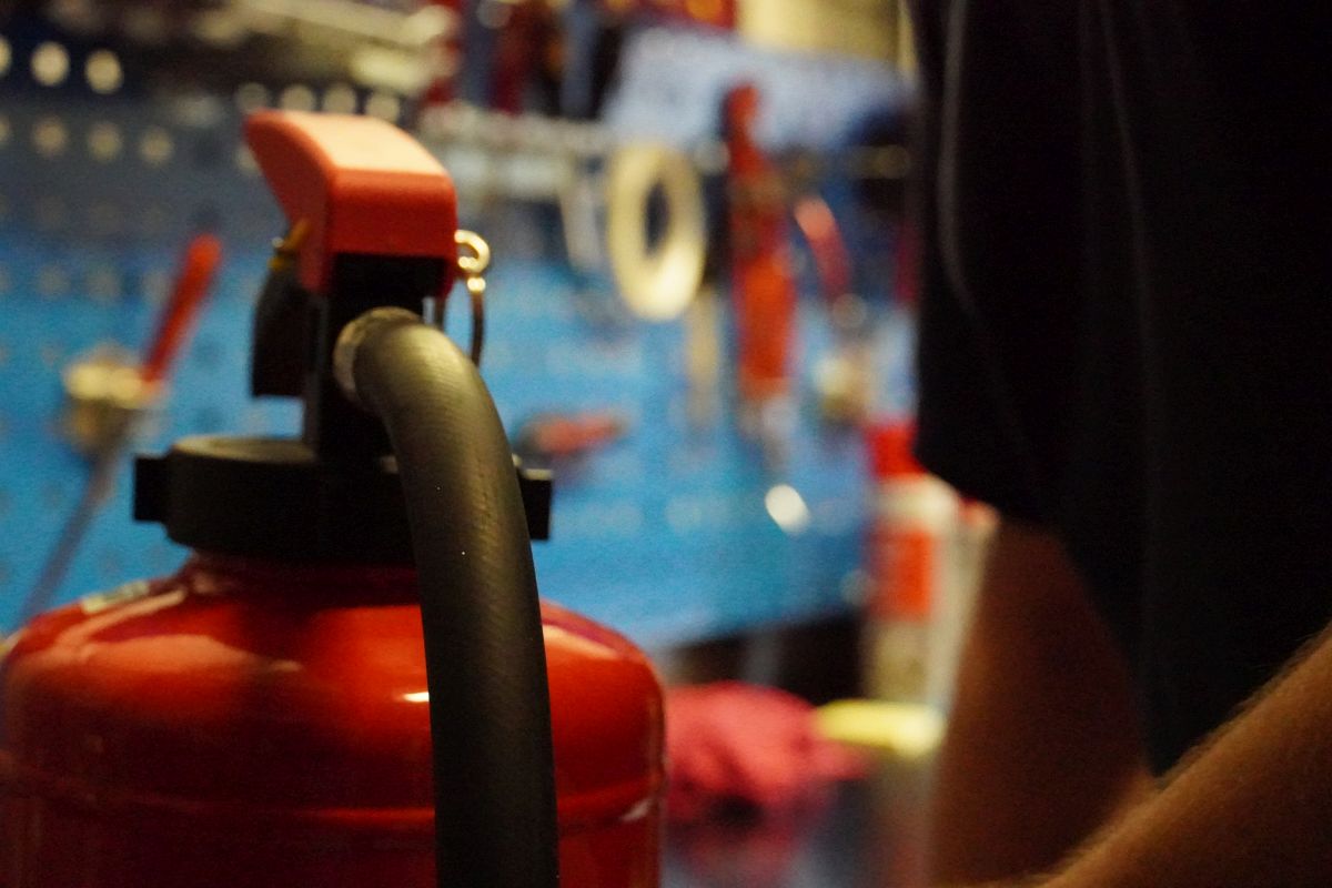 Feuerlöscher mit der Feuerlöscherwerkstatt im Hintergrund