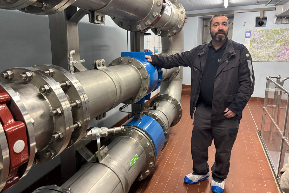 Thomas Illsinger steht an den Rohren des Wasserzulaufs