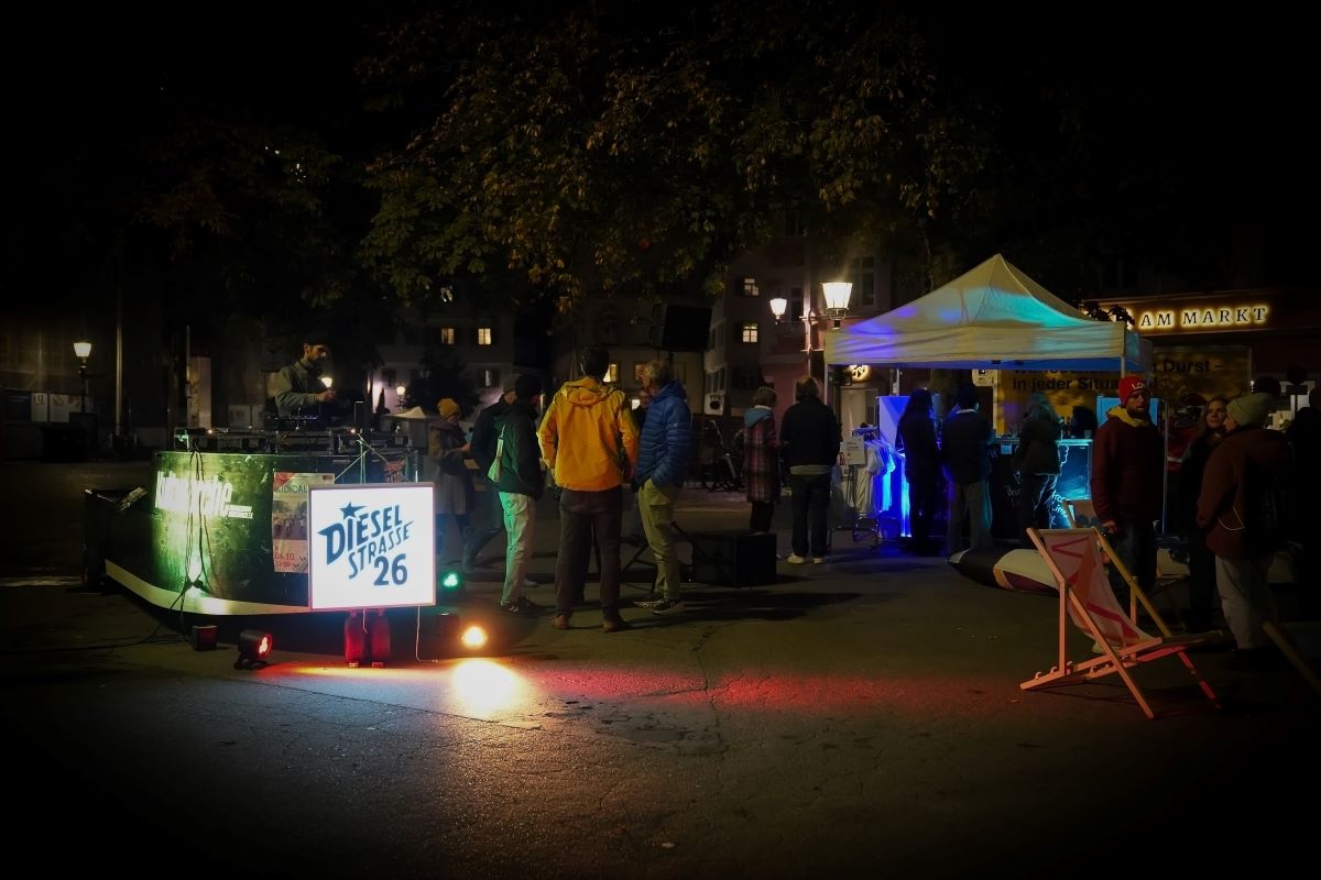 Kulturarche beim "Stadt im Fluss" Festival 2024 Das Holzboot Kulturarche steht nachts auf der Straße, umgeben von einer Menschenmenge