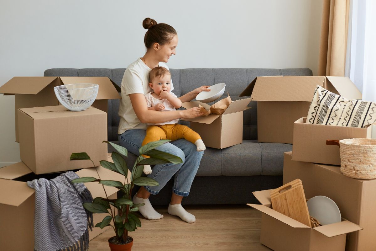 Glückliche Mieterin Junge Mutter mit Kind zieht in eine neue Wohnung ein