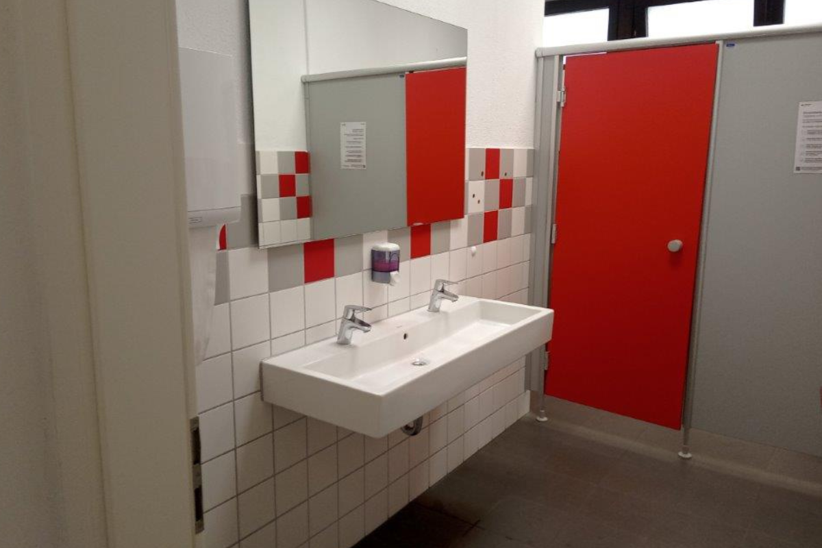 Schultoilette Vorraum einer sanierten Schultoilette in rot-weiß.