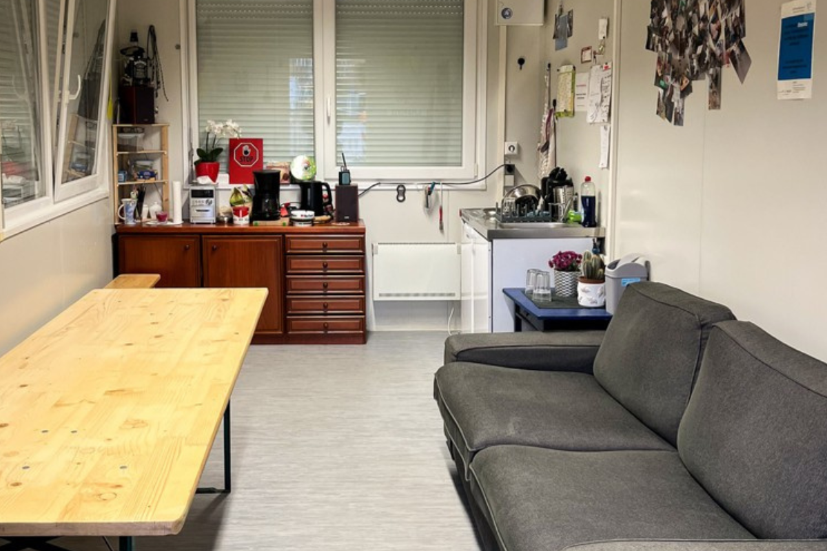 Innen Treff am Bahnhof mit Couch, Tisch und Schrank.