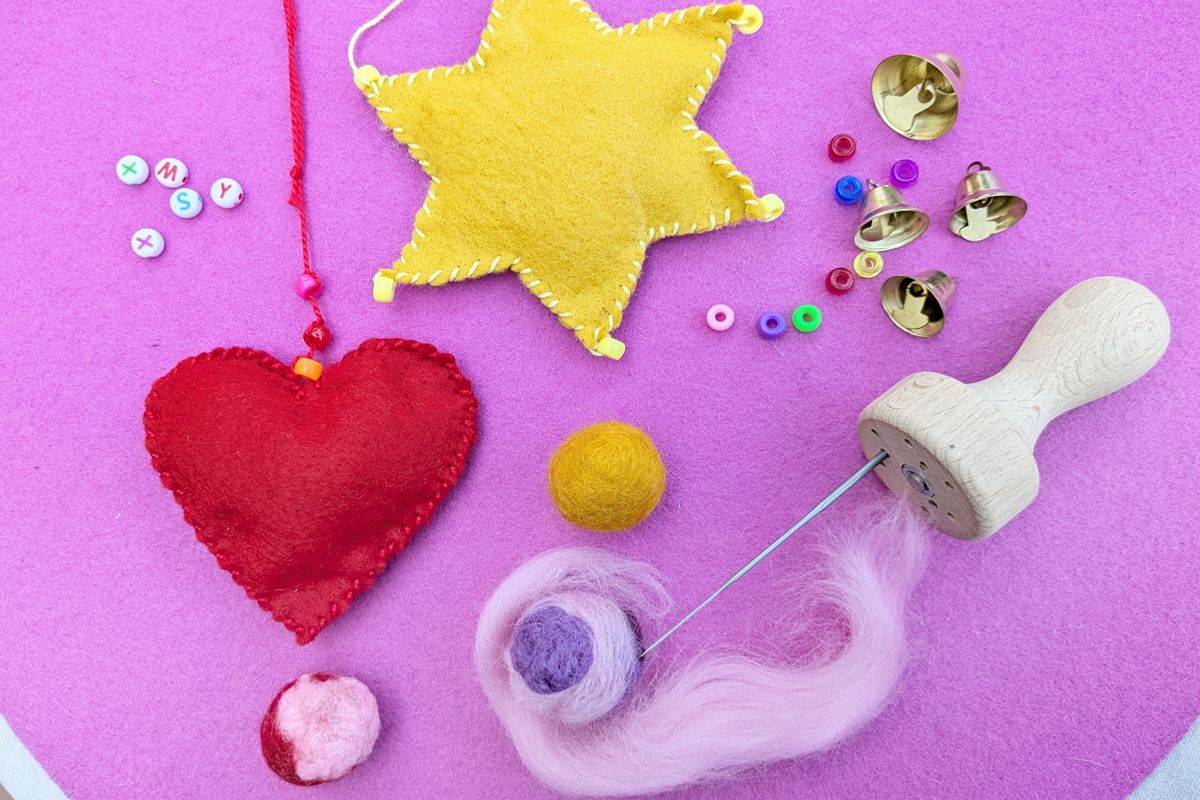 Sommerferien 2026 Filzen:Material und Beispiele, pinker Hintergrund Material wie Filzwolle und Perlen, fertig gebastelte und verzierte Anhänger aus Filzstoff in Stern- und Herzform Sommerferien 2026 Filzen: Material und Beispiele, pinker Hintergrund Material wie Filzwolle und Perlen, fertig gebastelte und verzierte Anhänger aus Filzstoff in Stern- und Herzform