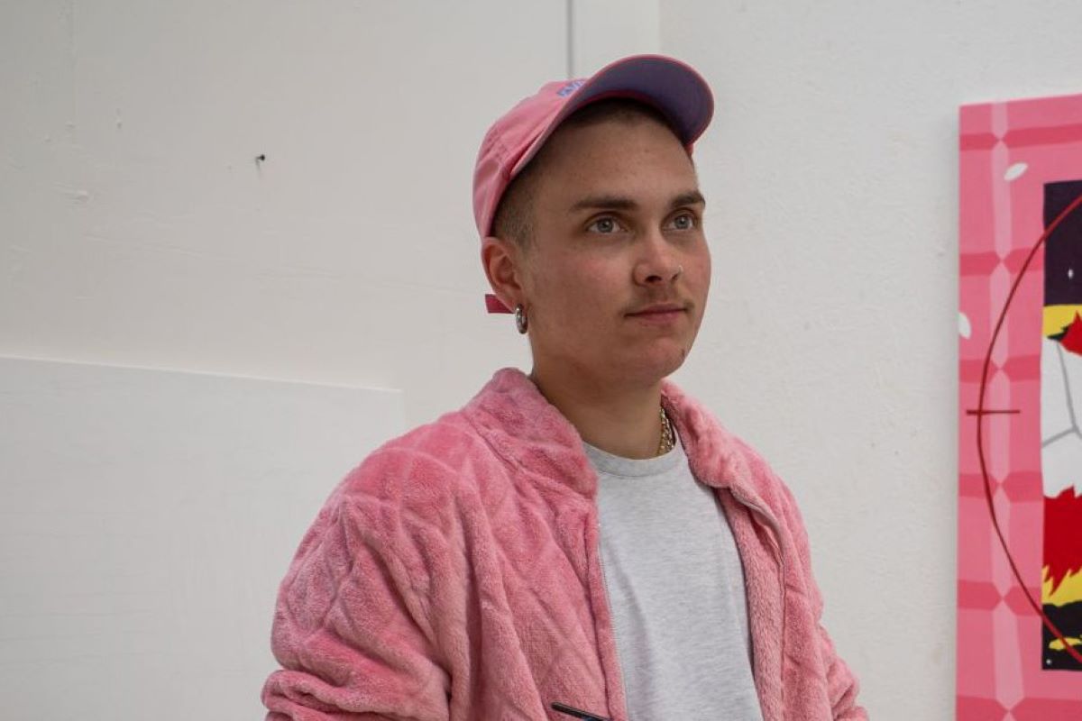 Junger Mann mit rosa Cap und rosa Plüschjacke